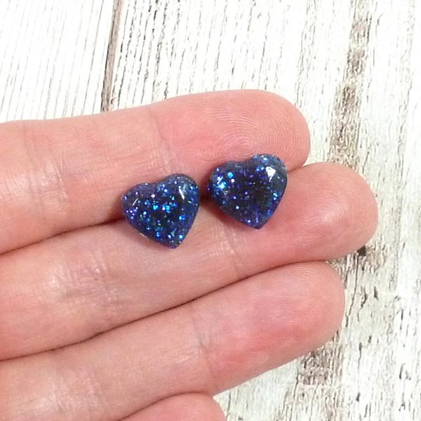 Blue glitter heart studs on hand