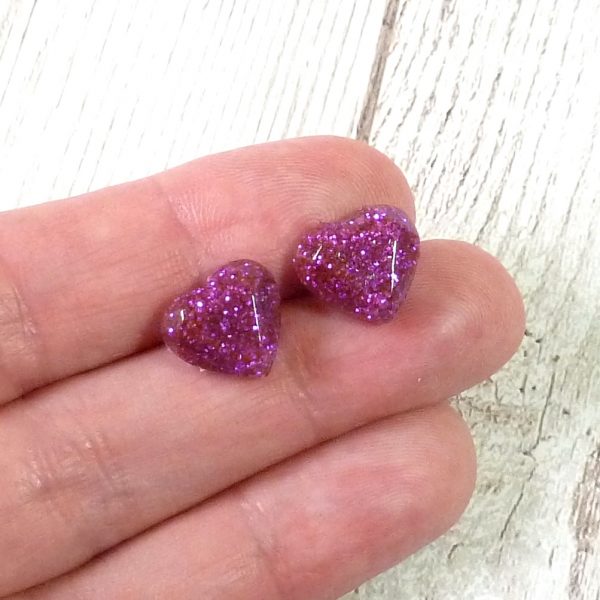 Purple glitter heart studs on hand