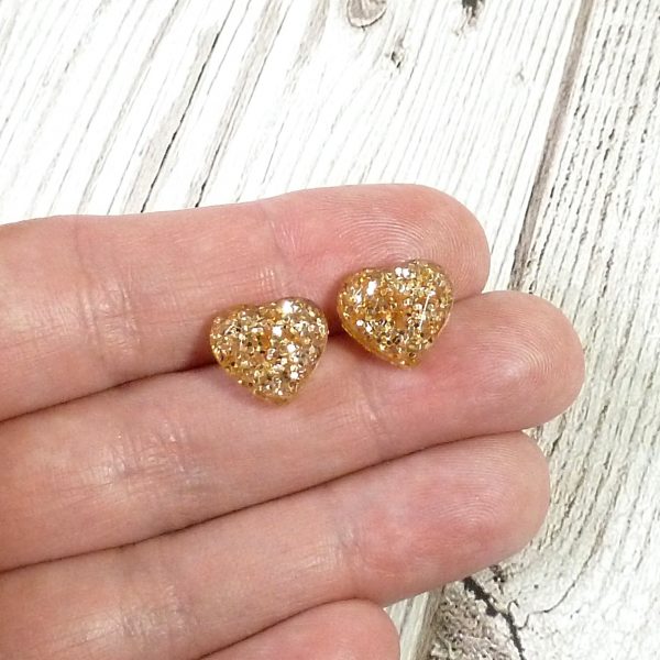 Gold heart studs on hand