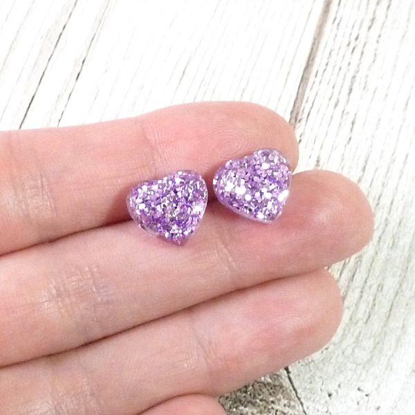 Lilac glitter heart studs on hand