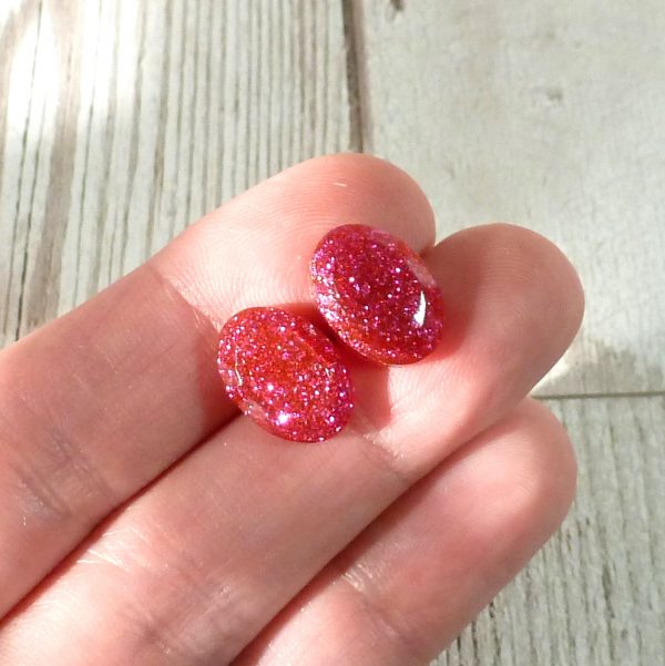 hot pink oval studs on hand
