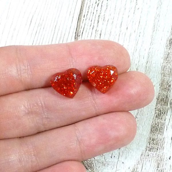 Red heart glitter studs on hand