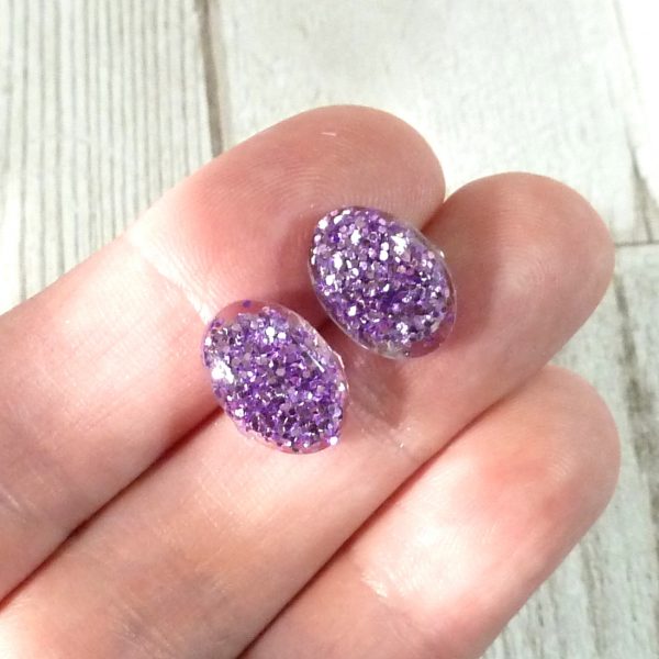 lilac glitter oval studs on hand