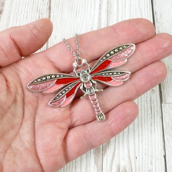 Red and Pink dragonfly on hand