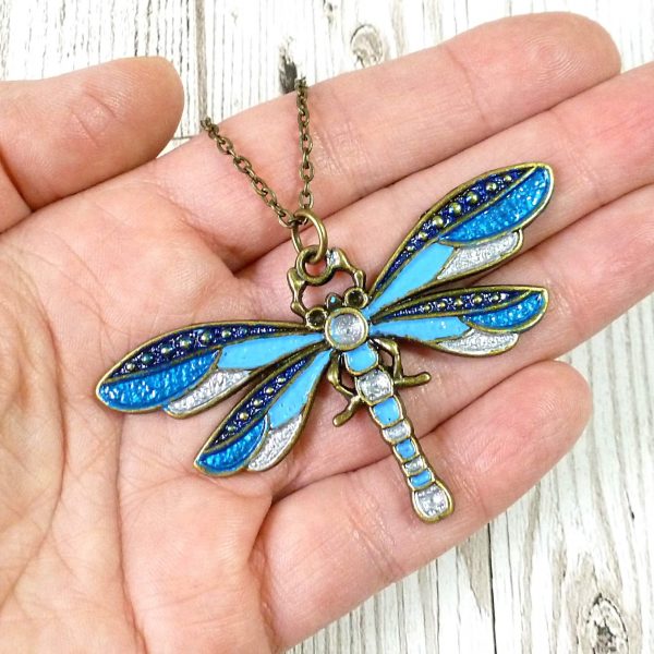 Blue and silver dragonfly pendant on hand