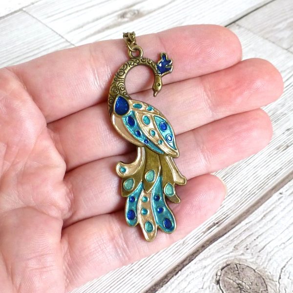 blue gold turquoise peacock on bronze on hand