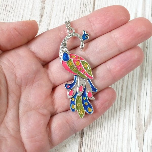 pink blue green yellow on silver peacock on hand