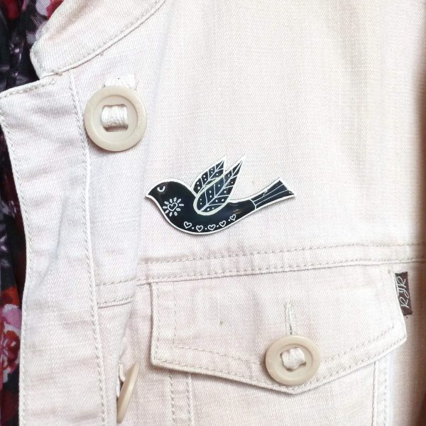 Black folk art style bird brooch on jacket