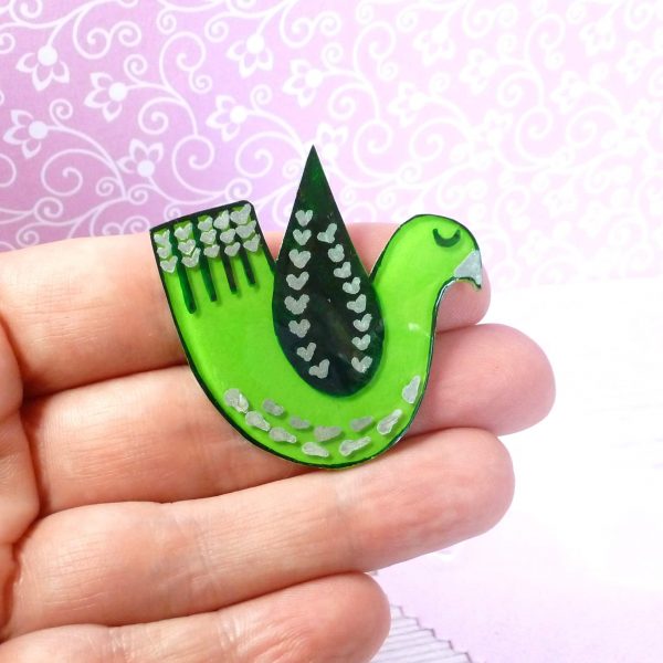 Green love bird brooch on hand