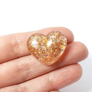 gold glitter heart pin on hand