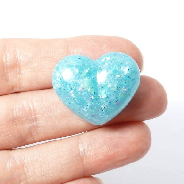 pale blue heart pin on hand