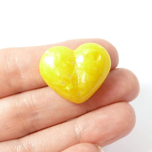 yellow heart pin on hand