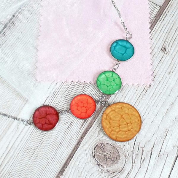 4 plus 1 rainbow necklace on wooden background