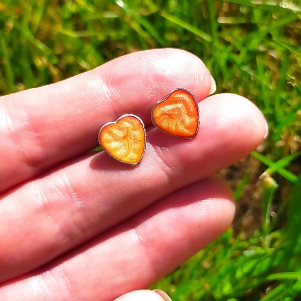 Orange Steel heart studs on hand