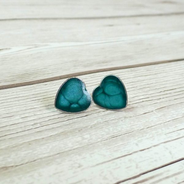 Turquoise heart studs on wooden bakground
