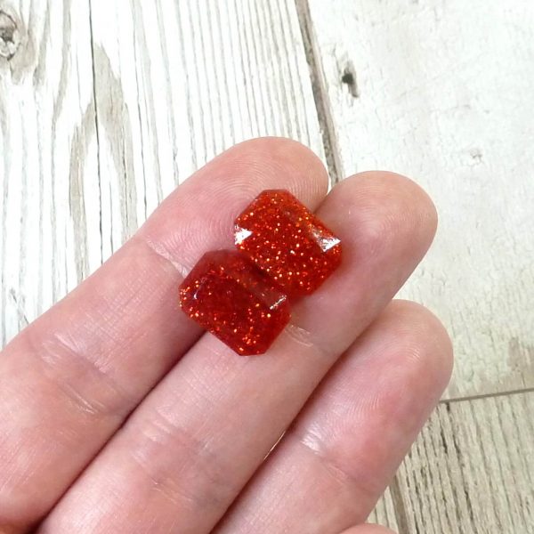 red small octogon studs on hand