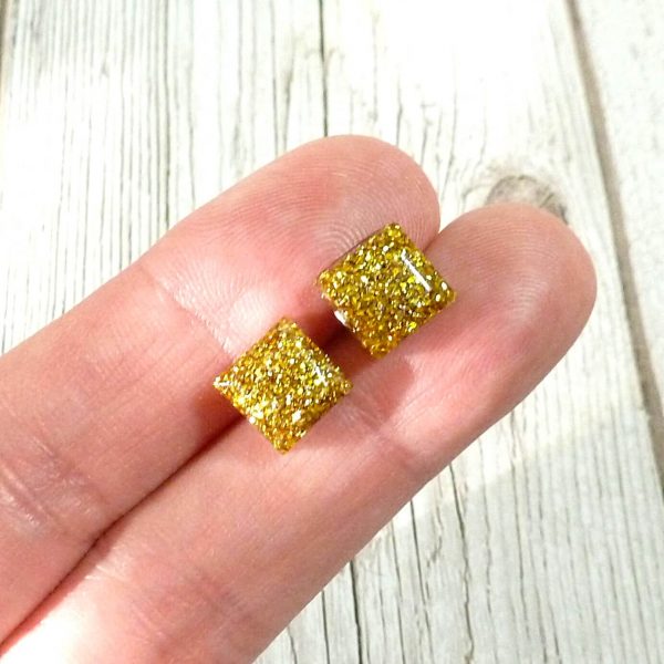 tiny antique gold square studs on hand