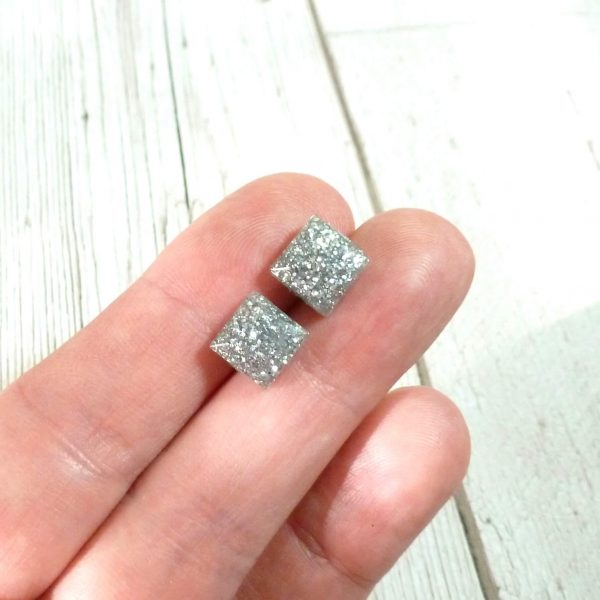 tiny silver square studs on hand